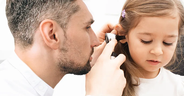 Doctor examining child's ear