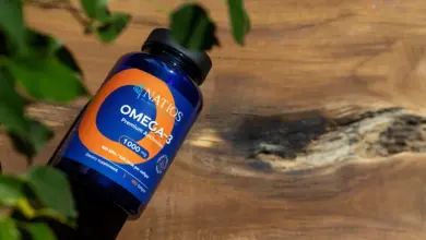 Modrá lahvička s doplňkem omega-3 na dřevěné desce.