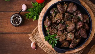 Připravená vepřová játra s čerstvou petrželkou na dřevěném podkladu