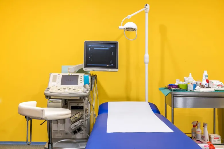 Místnost pro ultrazvukovou biopsii s přístrojem a stůl.