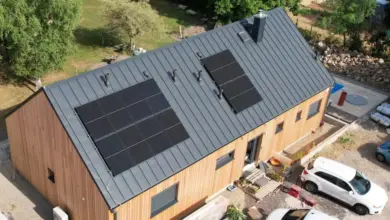 Dům s fotovoltaickými panely na střeše v přírodě.