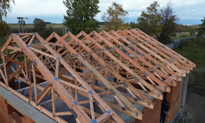 Stavba dřevěného krovu na domě s viditelnými vaznicemi.