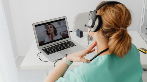 Žena v lékařském oblečení má online konzultaci s pacientem.