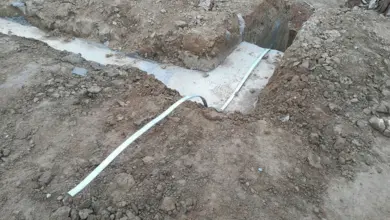 Bílý uzemňovací vodič položený v jámě u základové desky.