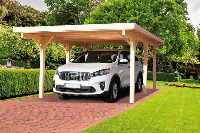 Bílý automobil pod nově postaveným dřevěným přístřeškem.