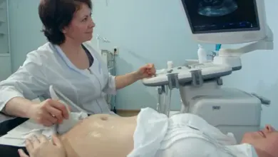 Lékařka provádí ultrazvukové vyšetření břicha těhotné ženy.