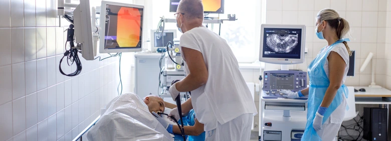 Lékaři provádějí ultrazvukové vyšetření pacienta v nemocničním prostředí.