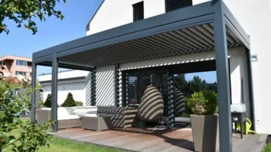 Moderní šedá pergola s venkovním posezením na dřevěné terase.