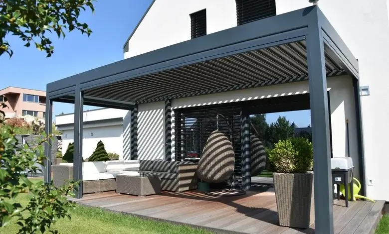 Moderní šedá pergola s venkovním posezením na dřevěné terase.