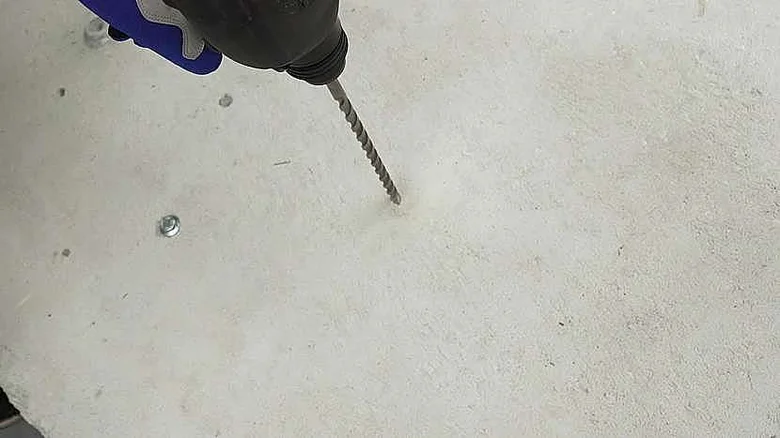 Vrták v betonu při práci s elektrickým vrtačkou.