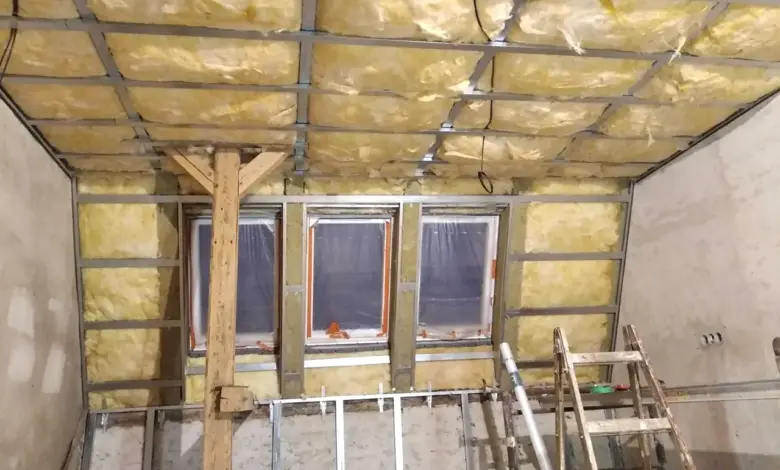 Stavba podkroví s izolací a kovovým rámem v průběhu rekonstrukce.