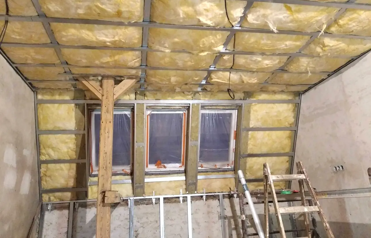 Stavba podkroví s izolací a kovovým rámem v průběhu rekonstrukce.