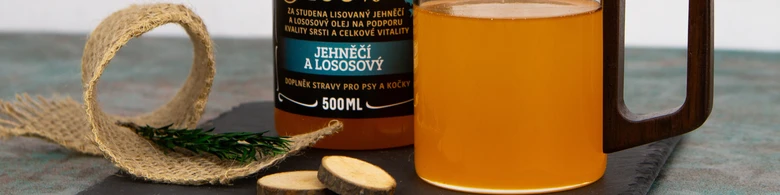 Fľaša oleje pro psy s lososem na tmavém podkladu.